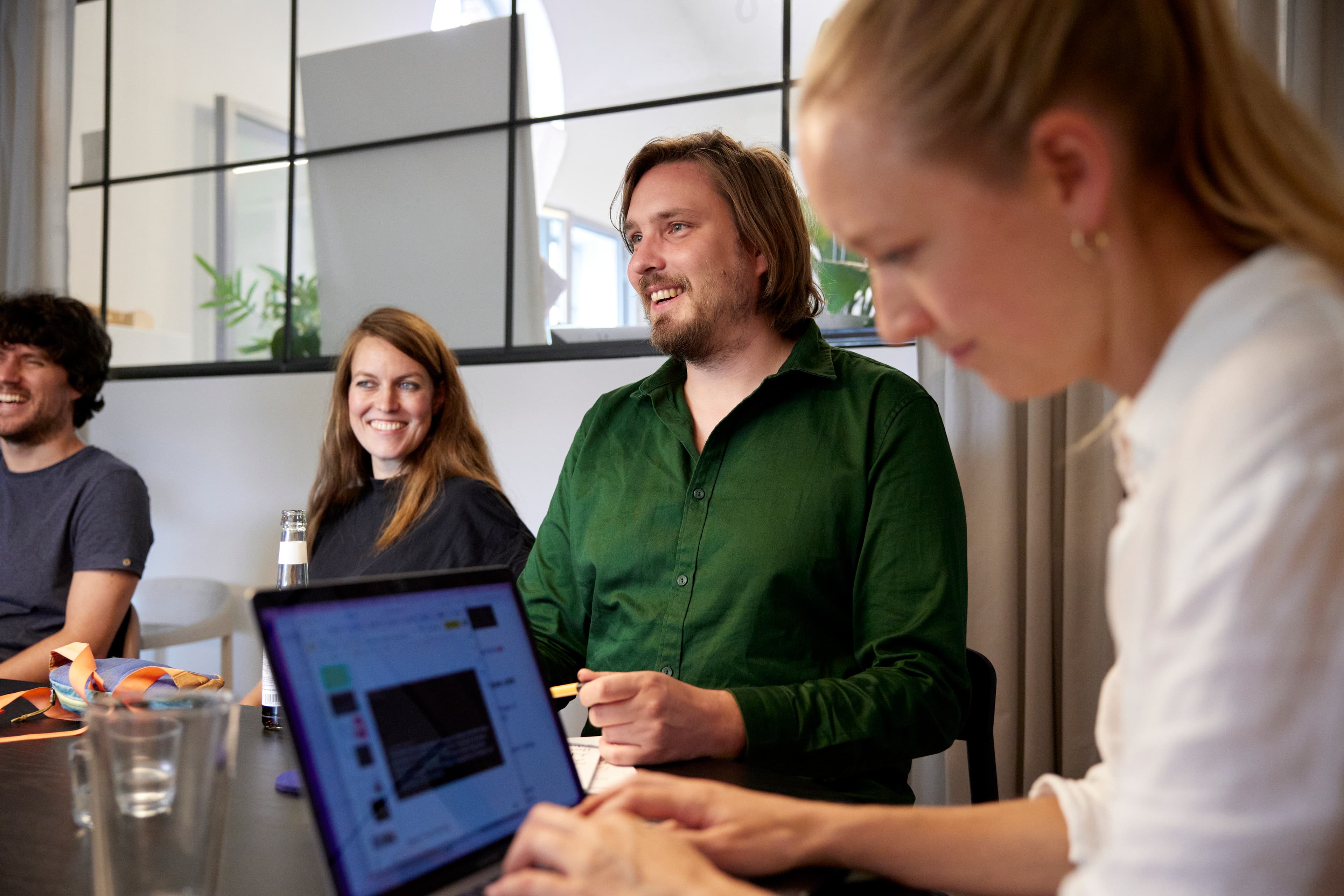 Vier Personen am Tisch im Besprechungsraum